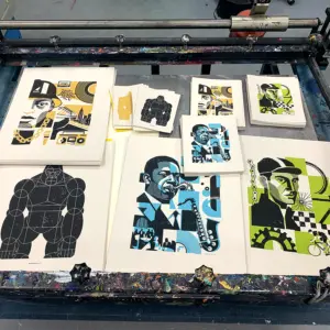 Foto of some fresh art prints by spiegelsaal.net The screenprinted art prints lay on a screenprint table.
