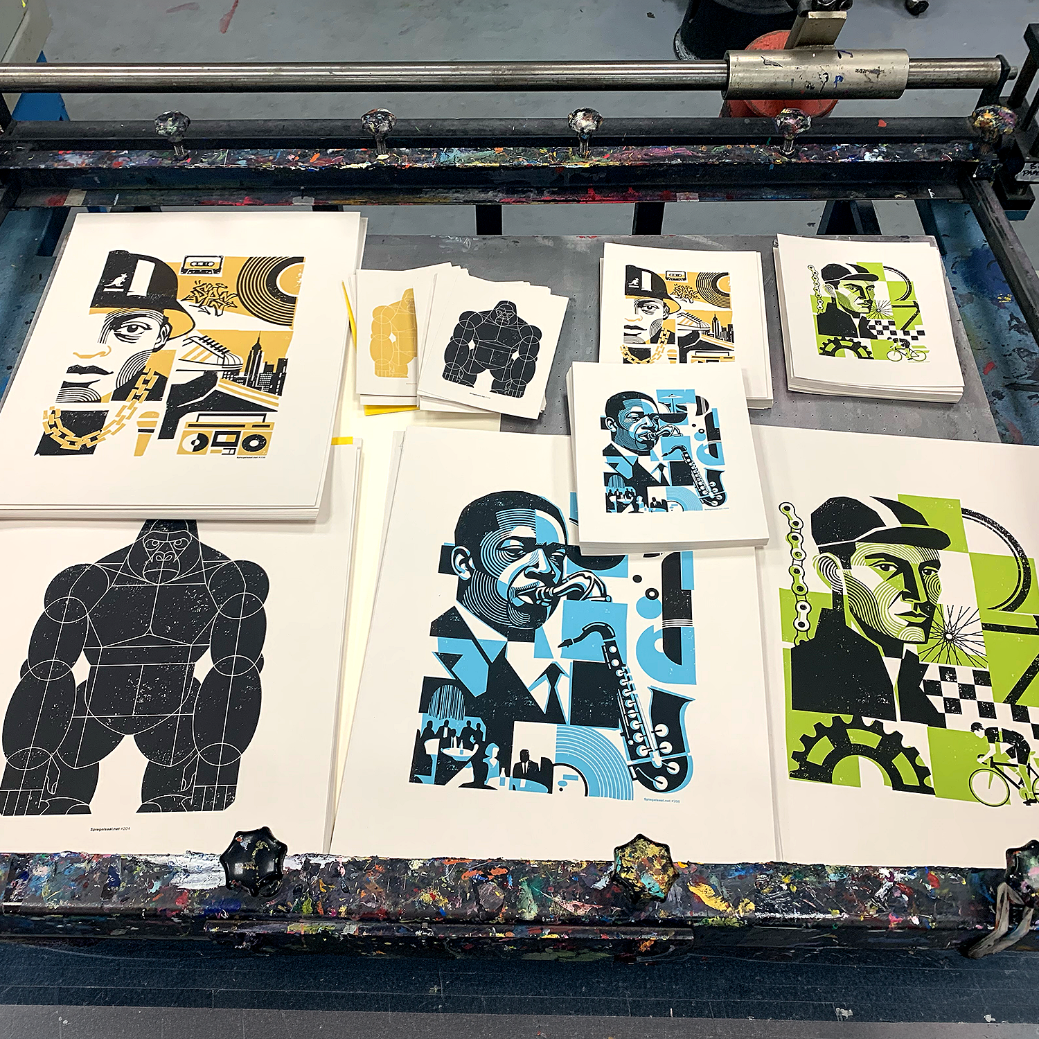 Foto of some fresh art prints by spiegelsaal.net The screenprinted art prints lay on a screenprint table.
